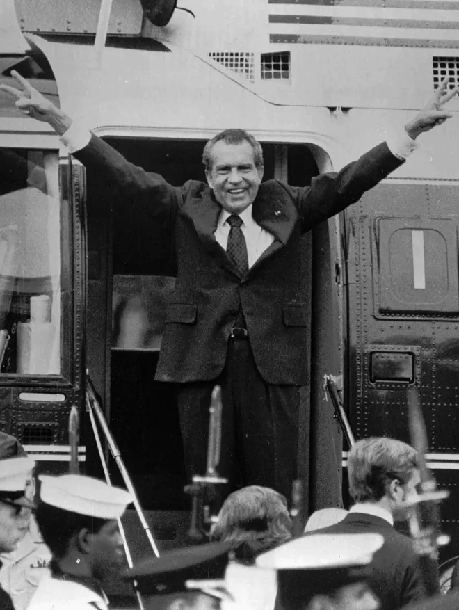 Former prez. Richard Nixon throws up double V signs before boarding the last helicopter out of the white house